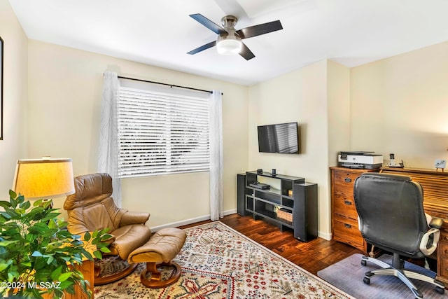 home office with ceiling fan and dark hardwood / wood-style flooring