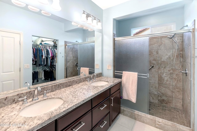 bathroom featuring walk in shower, vanity, and tile patterned flooring