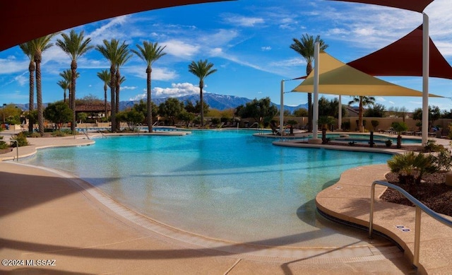 view of swimming pool with a patio area and a mountain view