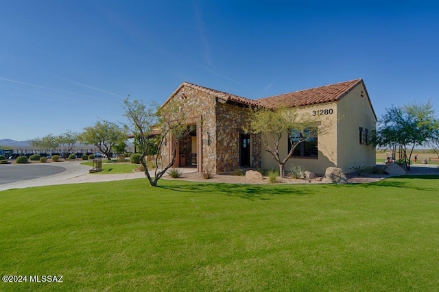 rear view of property featuring a lawn