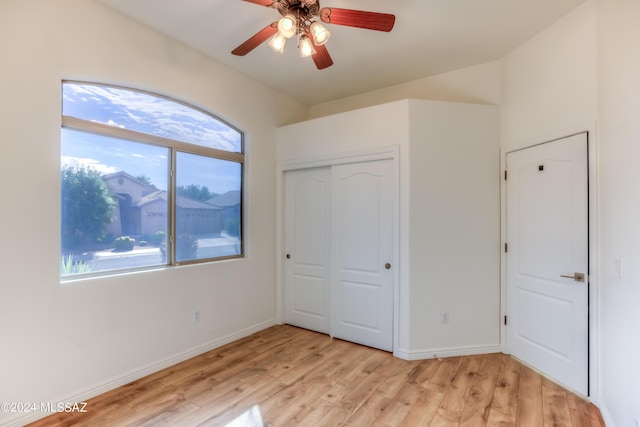 unfurnished bedroom with ceiling fan, a closet, and light wood-type flooring