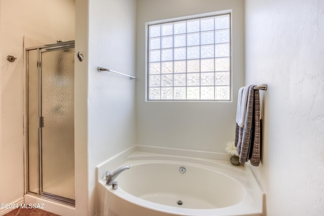 bathroom featuring shower with separate bathtub