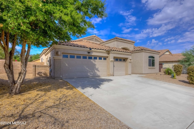 mediterranean / spanish-style house with a garage