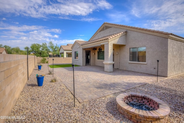 rear view of house featuring a patio and a fire pit