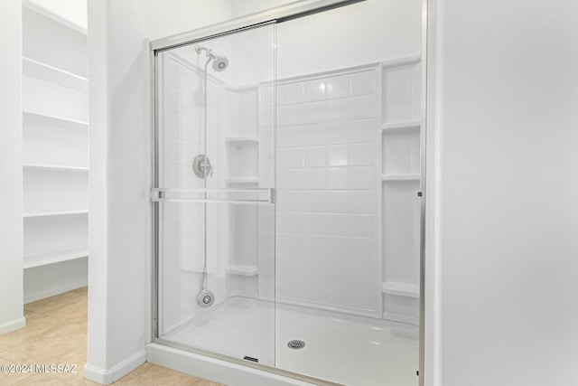 bathroom featuring tile patterned flooring and a shower with shower door