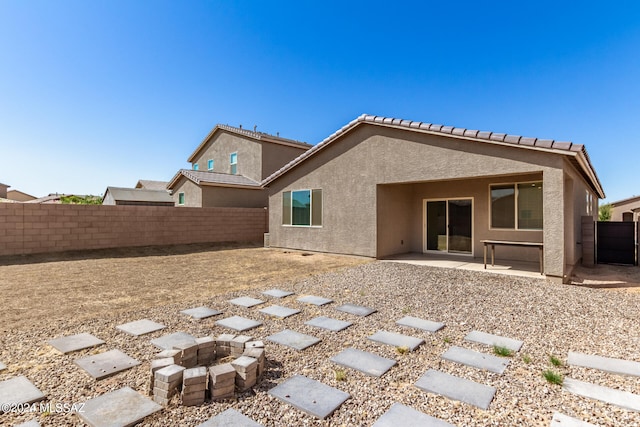 back of property with a fire pit and a patio area