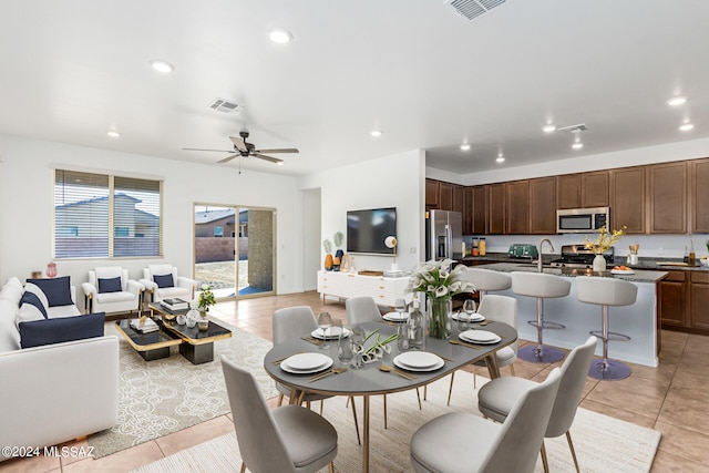 tiled dining space featuring sink and ceiling fan