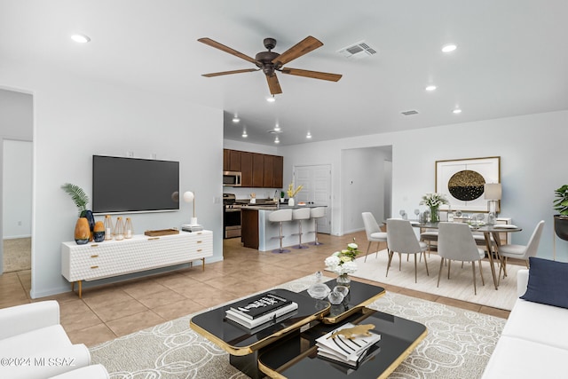 living room featuring light tile patterned floors and ceiling fan