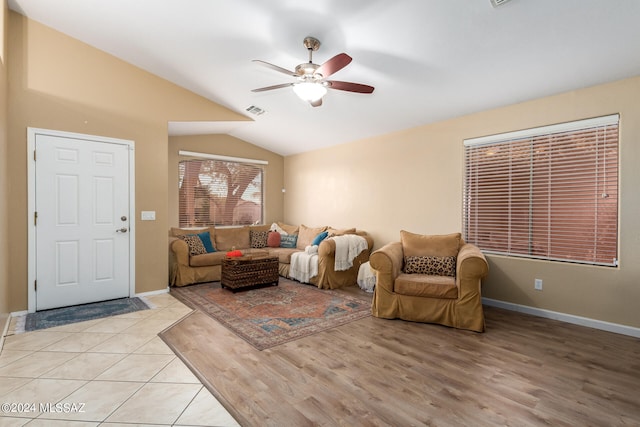 living room featuring ceiling fan, vaulted ceiling, and light hardwood / wood-style flooring