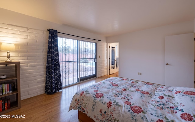 bedroom featuring wood finished floors and access to exterior