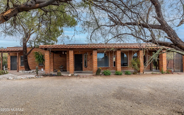 single story home featuring brick siding and covered porch