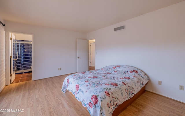 bedroom featuring wood finished floors and visible vents