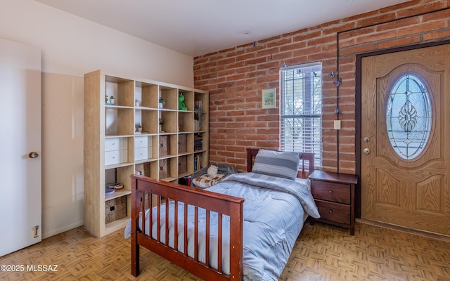 bedroom featuring brick wall