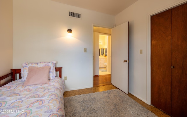 bedroom featuring baseboards, visible vents, and a closet