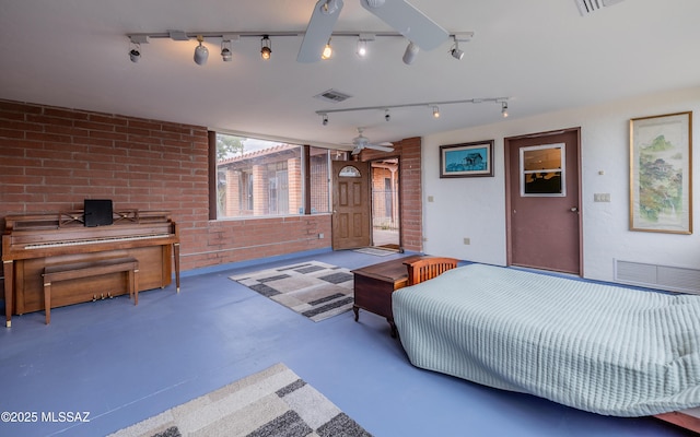 bedroom featuring finished concrete flooring, visible vents, and brick wall