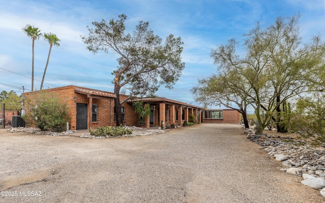 view of front of property featuring central AC unit and dirt driveway