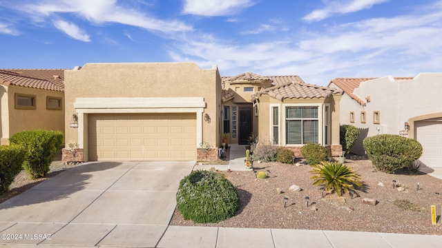 view of front of house with stucco siding, an attached garage, driveway, and a tiled roof