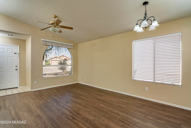 interior space featuring ceiling fan with notable chandelier, dark hardwood / wood-style floors, and vaulted ceiling