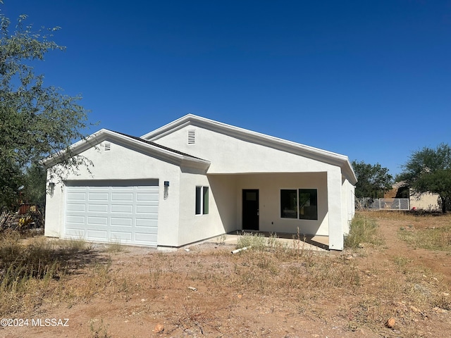 back of house featuring a garage