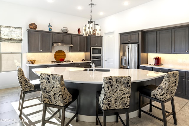 kitchen featuring visible vents, appliances with stainless steel finishes, tasteful backsplash, light stone countertops, and under cabinet range hood