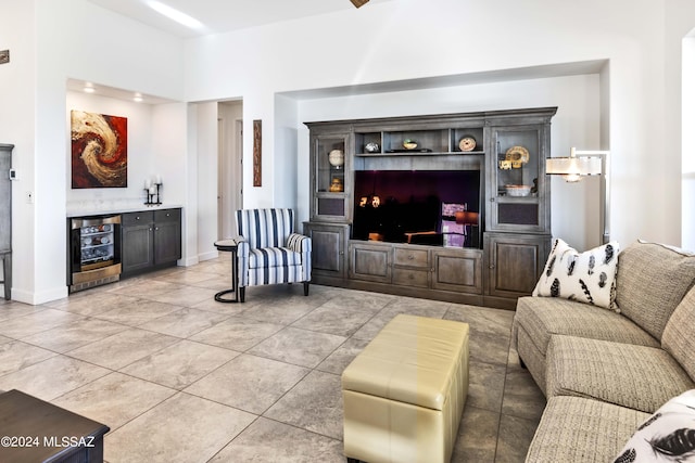 living area featuring light tile patterned floors, baseboards, and beverage cooler
