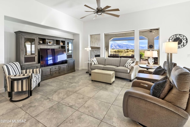 living room featuring tile patterned flooring, ceiling fan, and baseboards