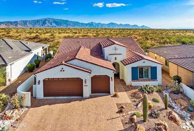 mediterranean / spanish-style house with a mountain view and a garage