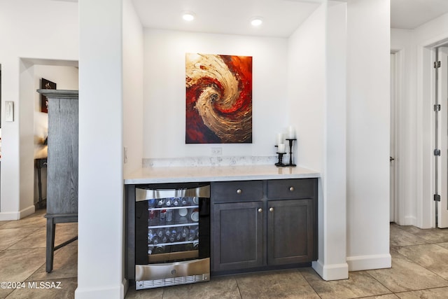bar featuring a dry bar, light tile patterned floors, baseboards, wine cooler, and recessed lighting