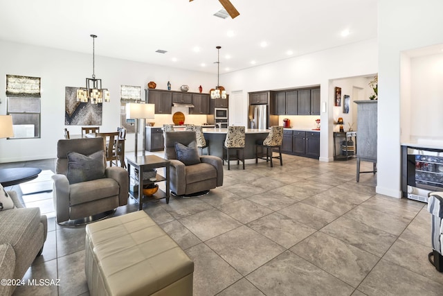 living room with beverage cooler, recessed lighting, ceiling fan with notable chandelier, and visible vents