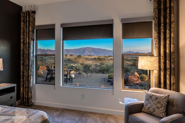 bedroom featuring tile patterned floors, a mountain view, and baseboards