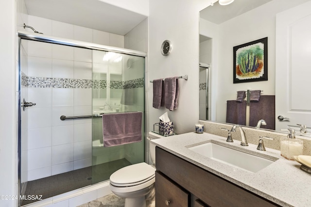 bathroom featuring vanity, a stall shower, and toilet