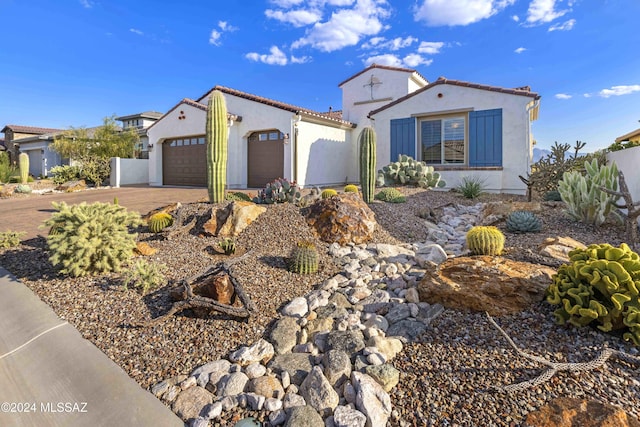 mediterranean / spanish house featuring concrete driveway, an attached garage, and stucco siding