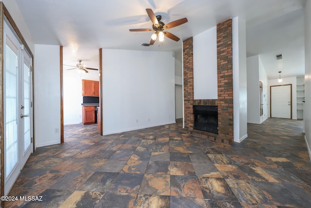 unfurnished living room featuring a brick fireplace and ceiling fan