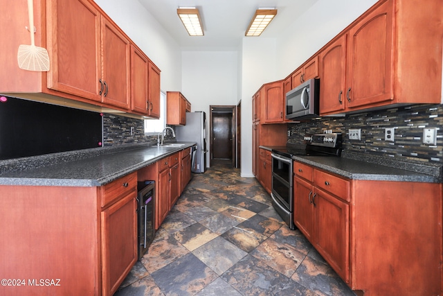 kitchen featuring decorative backsplash, appliances with stainless steel finishes, and sink