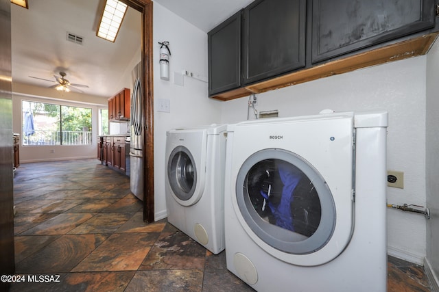 laundry area with ceiling fan, washing machine and clothes dryer, and cabinets