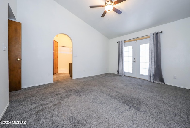 spare room featuring dark carpet, french doors, vaulted ceiling, and ceiling fan