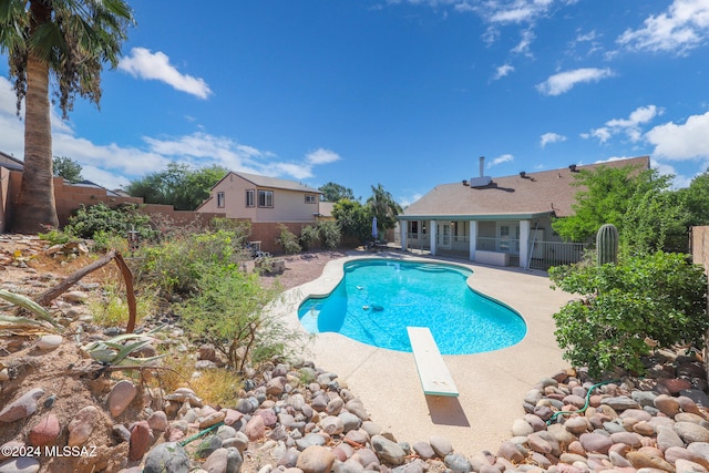 view of pool featuring a diving board and a patio area