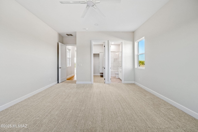 67970 E Madison Rd, Oracle, AZ 85623 - unfurnished bedroom with light carpet, a walk in closet, ensuite bath, a ceiling fan, and a closet