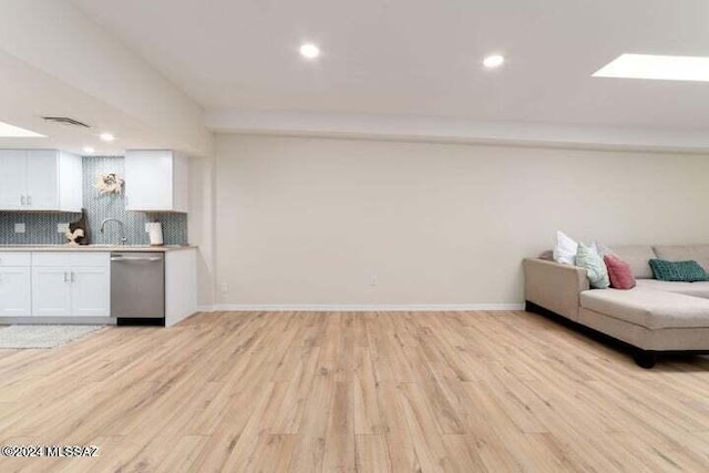 living room featuring light hardwood / wood-style floors and a skylight