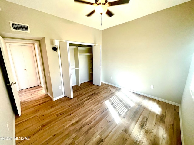 unfurnished bedroom with light hardwood / wood-style flooring, a closet, and ceiling fan