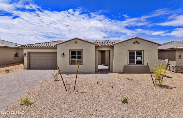 8257 S Silver Oak Dr, Tucson, AZ 85747 - mediterranean / spanish-style home with a garage, driveway, a tile roof, and stucco siding