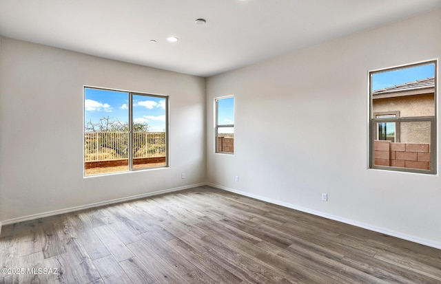 8257 S Silver Oak Dr, Tucson, AZ 85747 - empty room with wood finished floors, recessed lighting, and baseboards