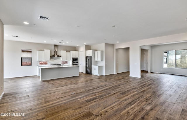 8257 S Silver Oak Dr, Tucson, AZ 85747 - unfurnished living room featuring dark wood-style flooring, recessed lighting, baseboards, and a sink