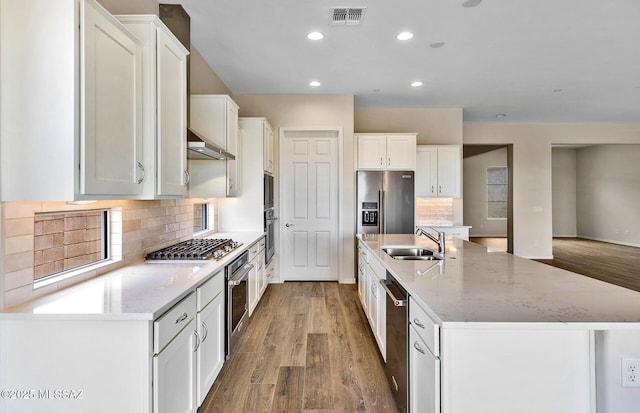 8257 S Silver Oak Dr, Tucson, AZ 85747 - kitchen with a sink, stainless steel appliances, white cabinets, a kitchen island with sink, and light wood finished floors