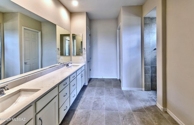 8257 S Silver Oak Dr, Tucson, AZ 85747 - bathroom with baseboards, double vanity, and stone finish flooring