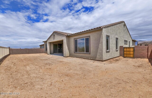 8257 S Silver Oak Dr, Tucson, AZ 85747 - back of house with a fenced backyard, stucco siding, and a gate
