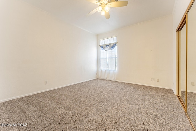 unfurnished bedroom featuring ornamental molding, ceiling fan, carpet floors, and a closet