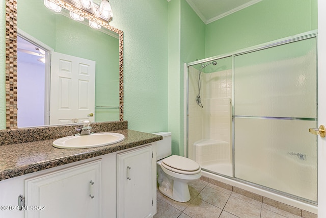 bathroom featuring vanity, a shower with door, tile patterned floors, ornamental molding, and toilet