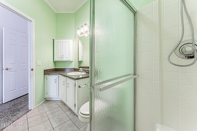 bathroom with vanity, toilet, ornamental molding, tile patterned flooring, and a shower with door