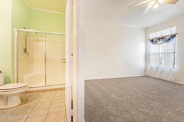 bathroom featuring tile patterned flooring, toilet, ornamental molding, a shower with door, and a textured ceiling